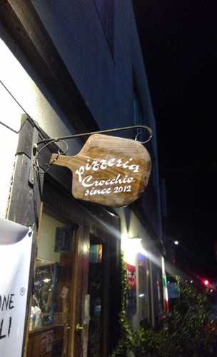 木製看板に貼られたレストランのカッティングシート 夜