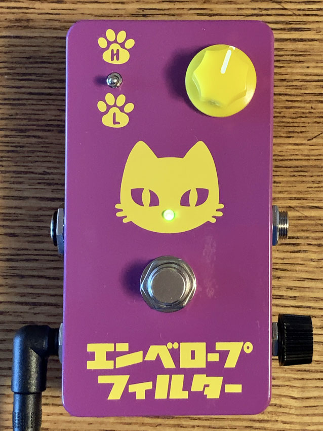 猫のイラストが書かれた紫のギターエフェクター