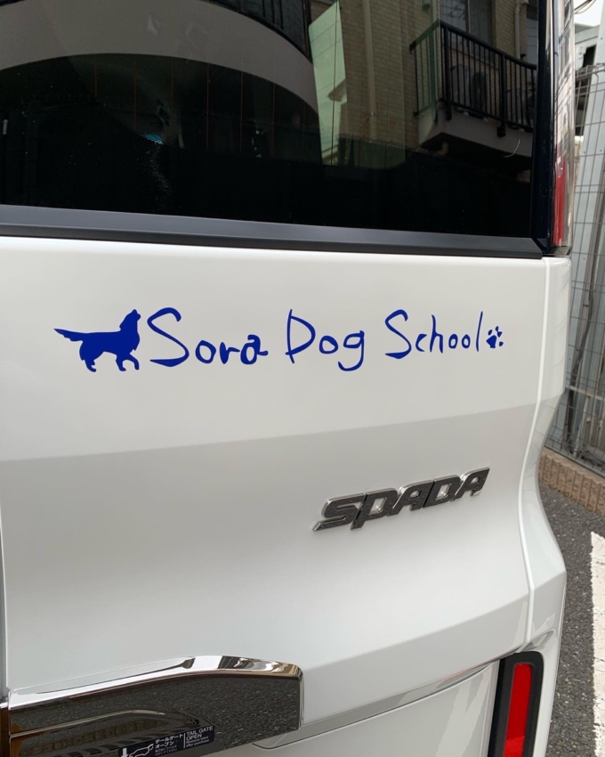 車のリアボディに貼られた犬のロゴマークのカッティングシート