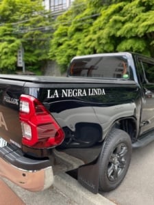 大きい車の荷台に貼られたカッティングシート「LA NEGRA LINDA」