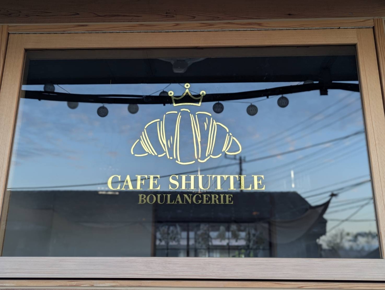 ガラスに貼られた中川ケミカル性のメタリックゴールドのカッティングシート