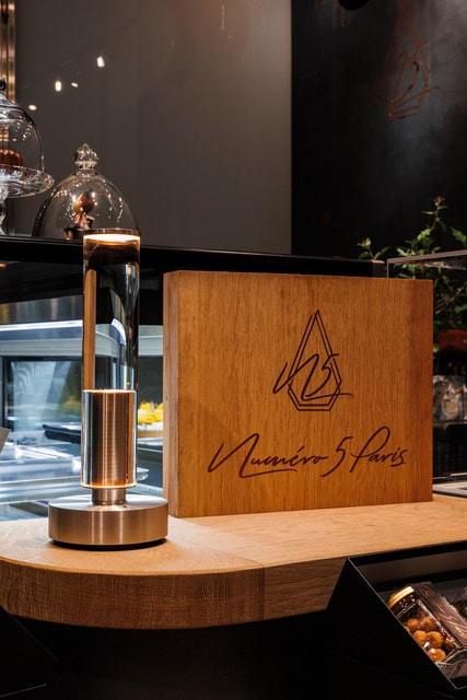 店舗名の木製銘板に貼られたカッティングシート